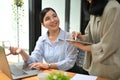 Beautiful Asian businesswoman asking a question and talking with her coworker Royalty Free Stock Photo