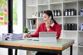 Beautiful Asian businesswoman or female secretary talking on the phone at her desk Royalty Free Stock Photo