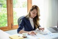 A beautiful Asian businesswoman or a financial analyst focused on working on her project Royalty Free Stock Photo