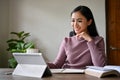 A beautiful Asian businesswoman focused on her work on her digital tablet, working at her desk Royalty Free Stock Photo