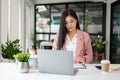 A beautiful Asian businesswoman focuses on her tasks, examining financial reports at her desk Royalty Free Stock Photo