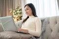 A beautiful Asian businesswoman is focusing on her laptop, working remotely at home Royalty Free Stock Photo