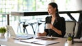 Beautiful asian businesswoman having a tasty morning coffee during work Royalty Free Stock Photo