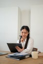 A beautiful Asian businesswoman is reviewing business report at her desk, working in her office Royalty Free Stock Photo