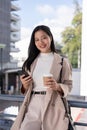 A beautiful Asian businesswoman is smiling at the camera and standing outdoors on a skywalk Royalty Free Stock Photo