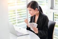 Beautiful businesswoman surprise and holding banknotes with laptop computer Royalty Free Stock Photo