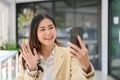 Beautiful Asian businesswoman talking with someone on a video call via her phone Royalty Free Stock Photo