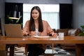 Beautiful Asian businesswoman using laptop computer, working in her private office Royalty Free Stock Photo
