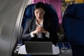 Beautiful Asian businesswoman working with laptop in aeroplane. working, travel, business concept