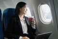 Beautiful Asian businesswoman working with laptop in aeroplane. working, travel, business concept