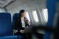 Beautiful Asian businesswoman working with laptop in aeroplane. working, travel, business concept