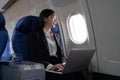 Beautiful Asian businesswoman working with laptop in aeroplane. working, travel, business concept