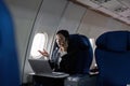 Beautiful Asian businesswoman working with laptop and mobile in aeroplane. working, travel, business concept