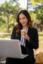 A beautiful Asian businesswoman is working remotely in a park in the afternoon Royalty Free Stock Photo