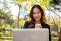 A beautiful Asian businesswoman is working remotely in a park in the afternoon Royalty Free Stock Photo