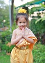 Beautiful Asian child girl in traditional thai dress praying in the public garden Royalty Free Stock Photo