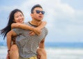 Beautiful Asian Chinese couple with boyfriend carrying woman on