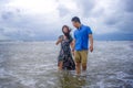Beautiful Asian Chinese couple walking together holding hands on the beach happy in love enjoying holidays Royalty Free Stock Photo