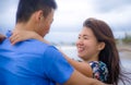 Beautiful Asian Chinese couple walking together holding hands on the beach happy in love enjoying holidays Royalty Free Stock Photo