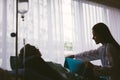 Beautiful Asian doctor taking care of senior patient in hospital bed. Attentive kind caregiver smiling and giving blanket