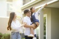 Beautiful family portrait smiling outside their new house with sunset Royalty Free Stock Photo