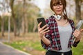 Beautiful Asian female college student using her phone while walking in the campus park Royalty Free Stock Photo