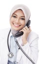 Beautiful asian female doctor talking on the phone Royalty Free Stock Photo