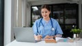 A beautiful Asian female doctor is working and reading medical research on her laptop Royalty Free Stock Photo