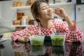 Beautiful asian female farmer eating homegrown organic vegetables on the table deliciously