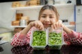 Beautiful asian female farmer shows off her organically grown vegetables on a table with a smile