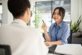 A beautiful Asian female HR recruiter is interviewing a candidate in the office