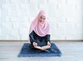 Beautiful young asian muslim woman reading quran Royalty Free Stock Photo