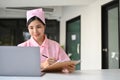 Beautiful Asian female nurse in her uniform working at her office desk Royalty Free Stock Photo