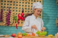 Beautiful asian female professional chef stirring bowl of fresh green vegetables with a spatula in kitchen full of cooking Royalty Free Stock Photo