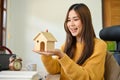 A beautiful Asian female putting a house model on her hands. Real estate agent, home buyer concept Royalty Free Stock Photo