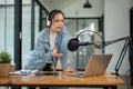 A beautiful Asian female radio host or radio journalist is speaking into a microphone Royalty Free Stock Photo