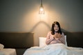 Beautiful asian female using smart phone on bed at late night,Eye diseases and eyes disorders concept Royalty Free Stock Photo