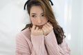 Beautiful Asian girl cold wearing white earmuffs and warm sweater pink cold at home, Concept woman lifestyle and winter.