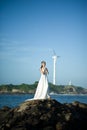 Beautiful Asian girl dressed in white dress enjoying sea breeze by the sea Royalty Free Stock Photo