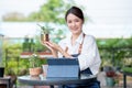 Beautiful Asian girl hold plant product and present to camera with smiling. Sustainable with small business work involve with