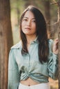 Beautiful asian girl leaned against a tree portrait in the forest with sunlight in the background Royalty Free Stock Photo