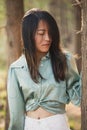 Beautiful asian girl leaned against a tree portrait in the forest with sunlight in the background Royalty Free Stock Photo
