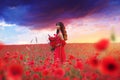 Beautiful Asian girl on the background of a blooming wild poppy field Royalty Free Stock Photo