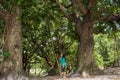 Beautiful asian girl looking at the big trees inside tropical forest