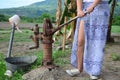 Beautiful Asian woman on a manual water pump in a small village in the Philippines.