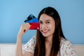 A beautiful Asian girl, is ordering online through a laptop computer, holding three credit cards in her hand, in order to choose Royalty Free Stock Photo