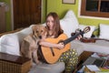 Beautiful asian girl playing guitar happily with dog