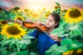 Asian girl playing violin in mist of sun flower field Royalty Free Stock Photo