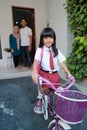 girl primary student going to school by riding a bike in the morning