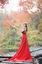 Beautiful Asian girl in red dress frolicking in the countryside